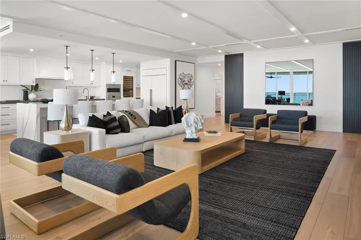 The living room connects to dual hallways leading to the guest suites, laundry room, and den