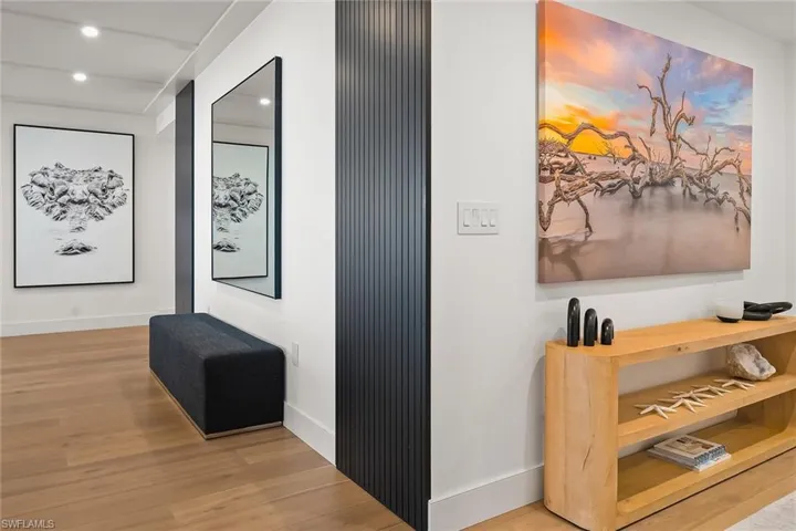 Welcoming entry gallery featuring Dennis Goodman art and a hallway leading to the south guest suite