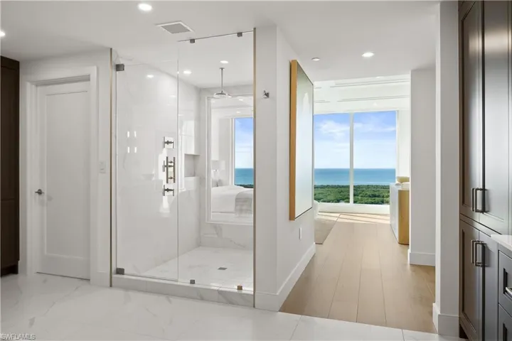Walk in glass shower with multiple showerheads and stunning views