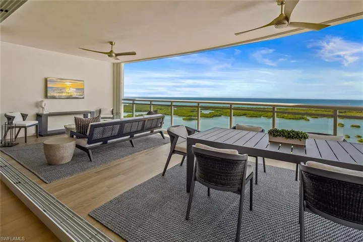 An expansive 32-foot sunset terrace seamlessly connected by pocketing impact doors, offering inviting outdoor living and dining spaces.