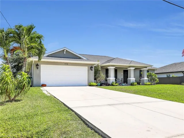 View of front of property with a front yard and a garage