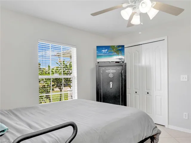 Bedroom featuring a closet, light tile flooring, and ceiling fan