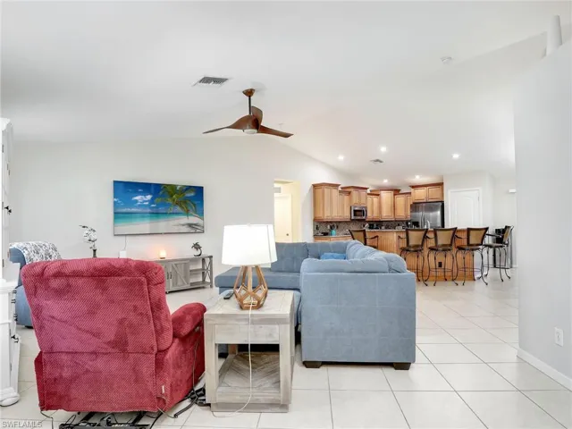 Living room with ceiling fan, and light tile flooring