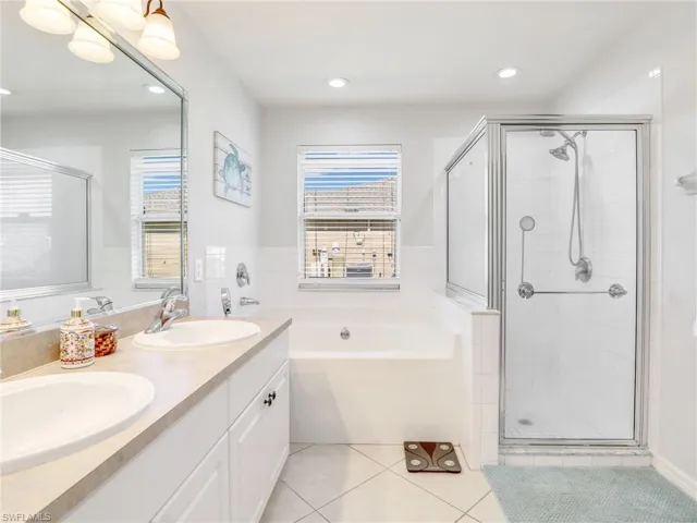 Bathroom with tile floors, plus walk in shower, oversized vanity, and double sink