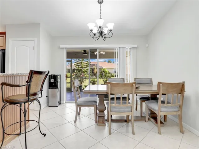 Tiled dining room with a chandelier