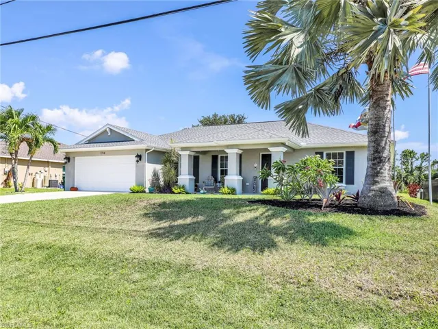 View of front of property with a front yard and a garage