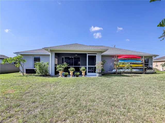 Back of house featuring a Lanai and a lawn