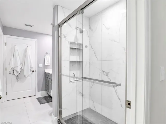 Bathroom featuring tile floors, and a shower with shower door