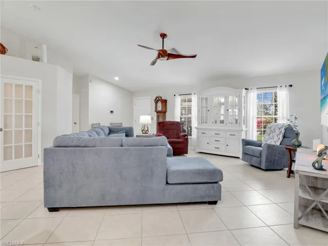 Living room with ceiling fan and light tile floors