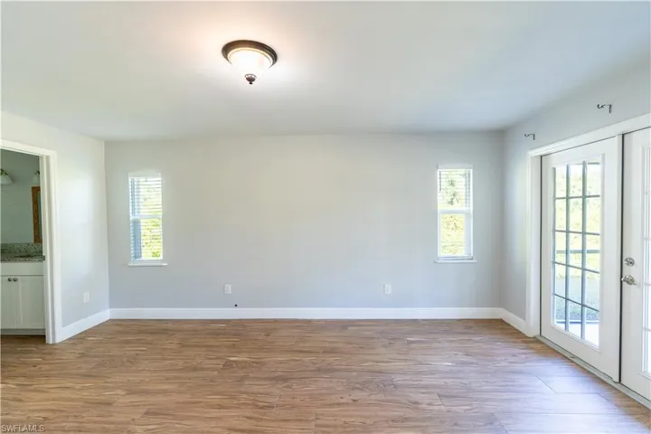 Spare room featuring french doors, light wood-type flooring, and plenty of natural light
