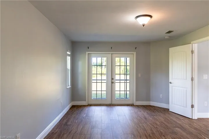 Unfurnished room featuring dark wood-type flooring and french doors