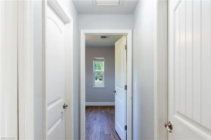 Hallway with dark wood-style floors and baseboards