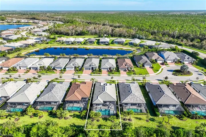 Aerial perspective of suburban area featuring a large body of water and property boundaries highlighted