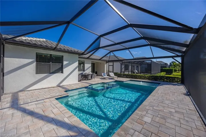 View of swimming pool with a sunroom, a patio area, a pool with connected hot tub, and a lanai