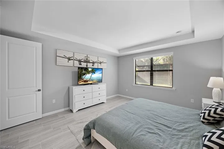 Bedroom featuring a raised ceiling and wood finish floors