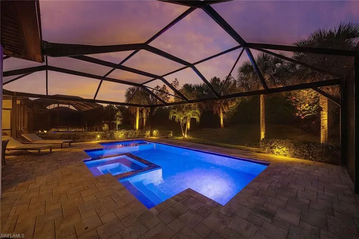 View of swimming pool with a lanai, a pool with connected hot tub, a patio area, and a sunroom