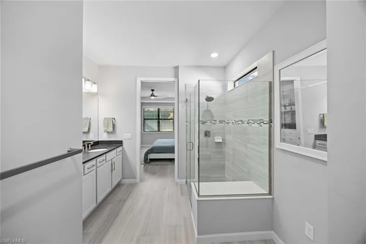 Ensuite bathroom featuring vanity, a stall shower, and recessed lighting