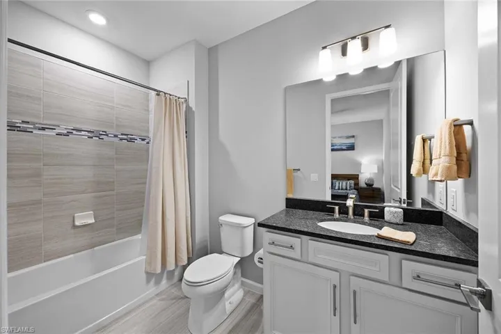 Ensuite bathroom featuring shower / tub combo and vanity