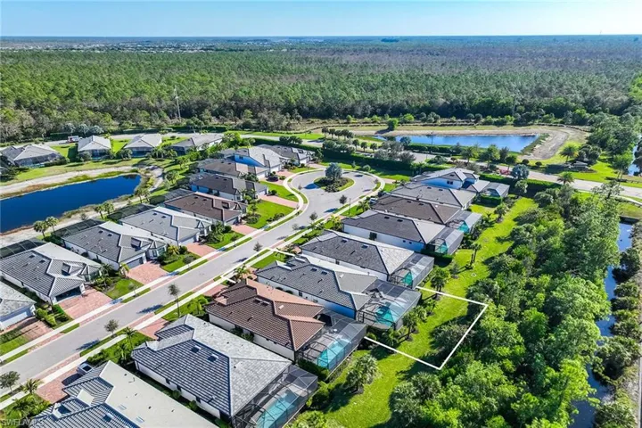 Aerial view of residential area with a large body of water and property parcel outlined
