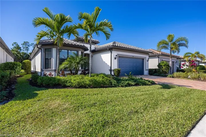 Mediterranean / spanish-style home with stucco siding, an attached garage, driveway, and a front yard