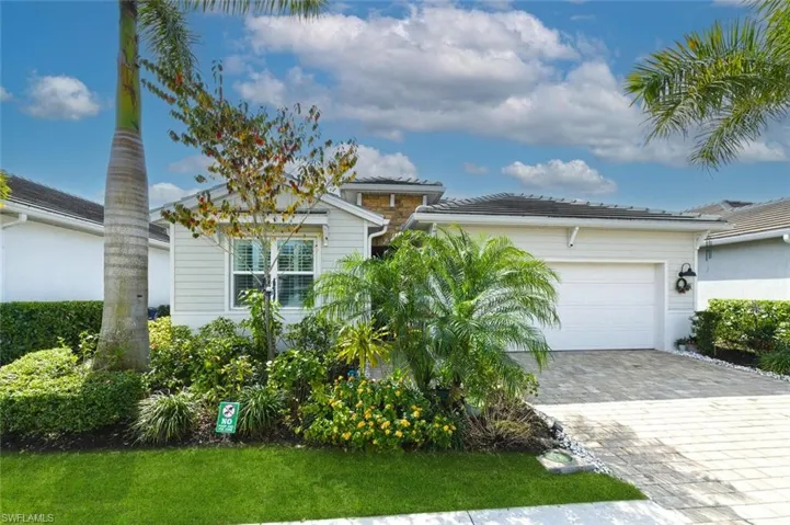 View of front of property featuring an attached garage and decorative driveway
