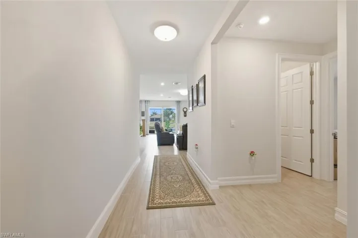 Hall featuring light wood finished floors and recessed lighting