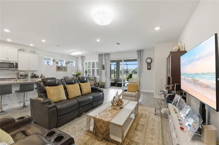 Living room with light wood-type flooring and recessed lighting