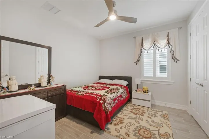 Bedroom with wood tiled floors and a ceiling fan