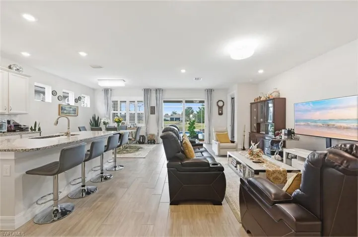 Living area with light wood-style floors and recessed lighting
