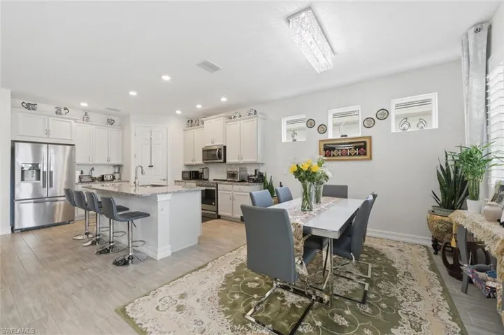 Dining room with light wood-style floors and recessed lighting