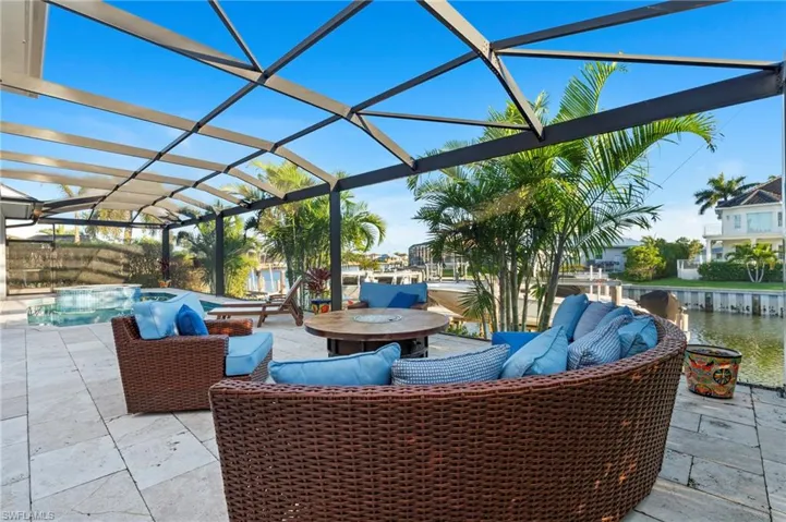 View of patio / terrace with an outdoor pool, a lanai, and a water view