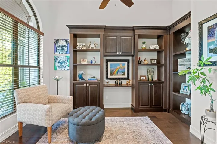 Sitting room with dark wood-style flooring, a ceiling fan, and baseboards