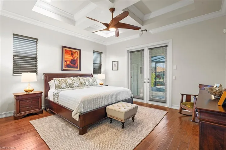 Bedroom with access to exterior, coffered ceiling, wood-type flooring, crown molding, and beam ceiling