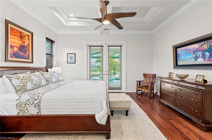 Bedroom with access to exterior, dark wood-style floors, french doors, crown molding, and a ceiling fan