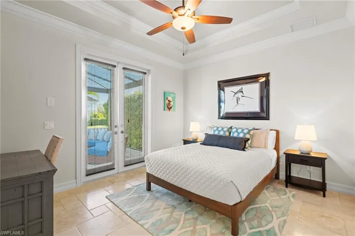 Bedroom with access to outside, stone tile flooring, ornamental molding, and baseboards