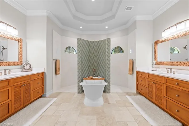 Full bath featuring recessed lighting, a walk in shower, two vanities, and ornamental molding