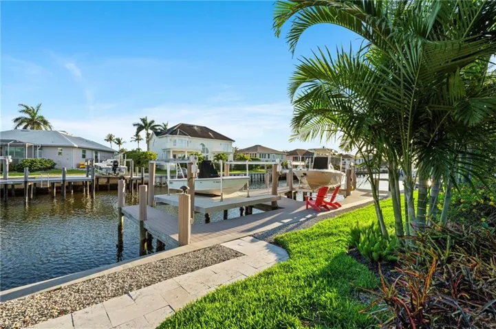 Dock with boat lift, a residential view, and a water view