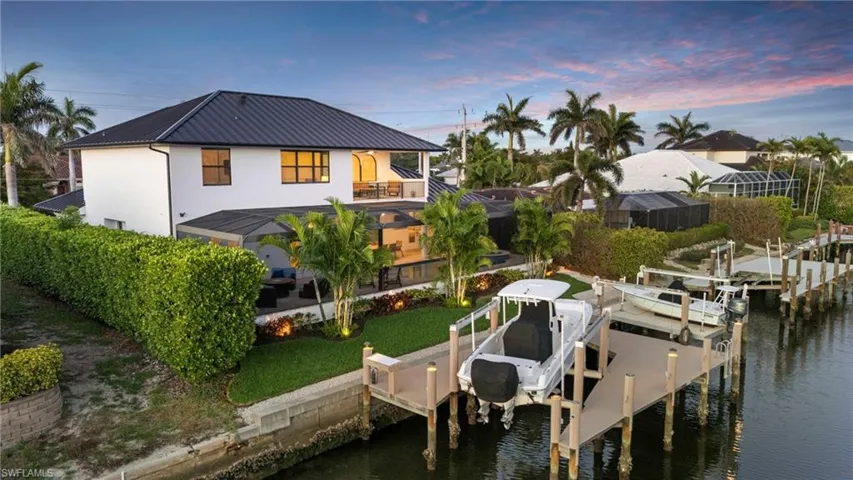 Dock with boat lift, a water view, and a balcony