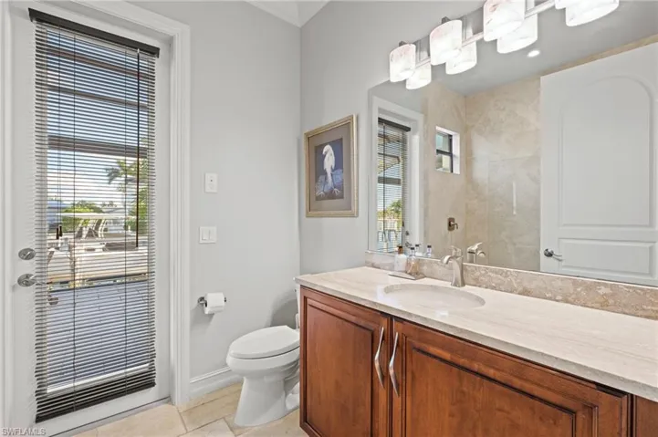 Bathroom with toilet, vanity, and tile patterned flooring
