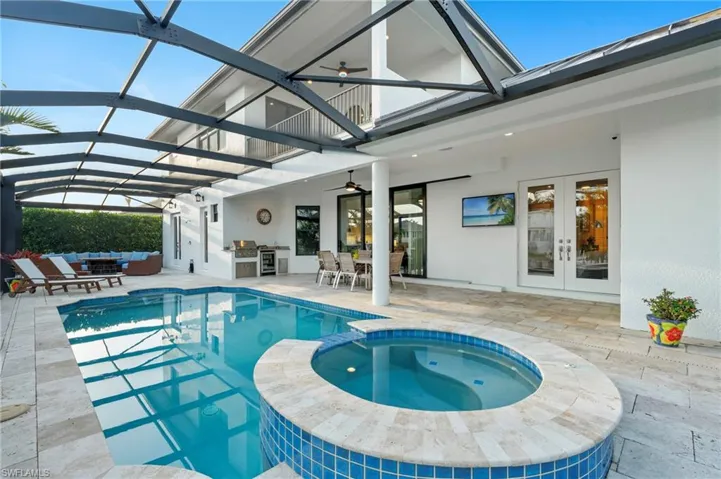 View of pool with french doors, exterior kitchen, a patio, and ceiling fan