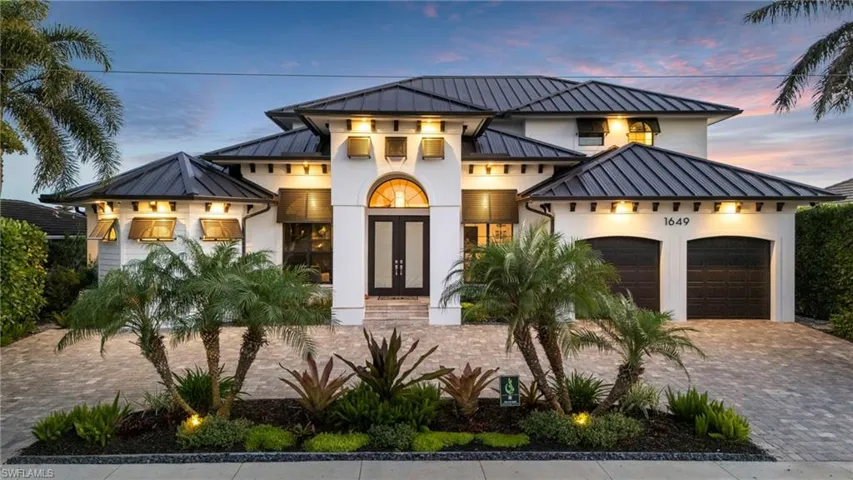 Contemporary home featuring a standing seam roof, french doors, metal roof, stucco siding, and an attached garage