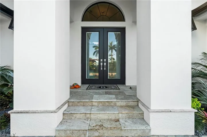 View of exterior entry with french doors and stucco siding