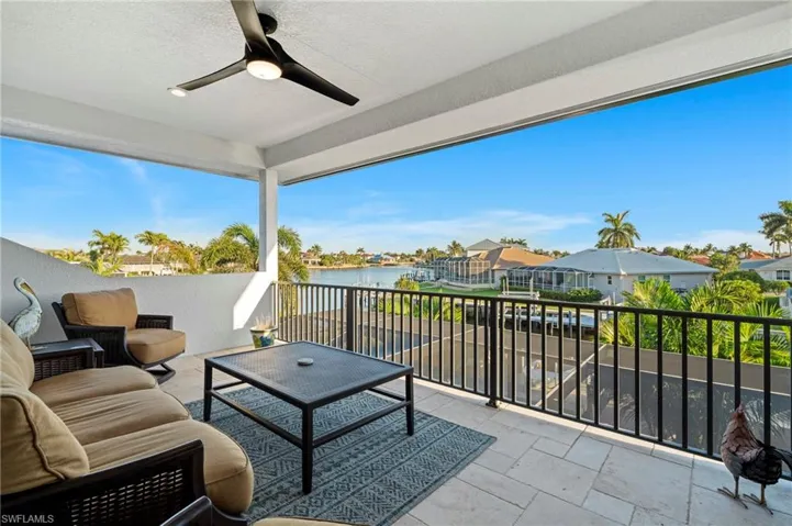 Balcony featuring a water view, a ceiling fan, and outdoor lounge area