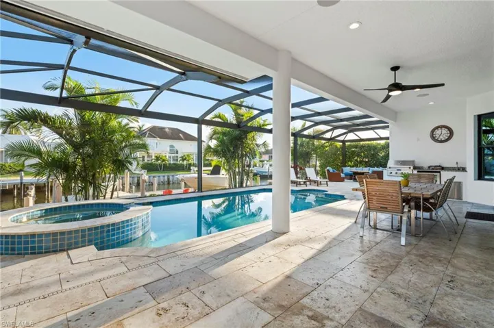 View of pool featuring an outdoor kitchen, a ceiling fan, area for grilling, and a patio area