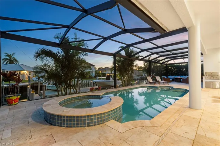 View of pool featuring a pool with connected hot tub, a patio, an outdoor kitchen, and area for grilling
