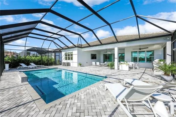 Outdoor pool with a sunroom, a patio, ceiling fan, and a lanai