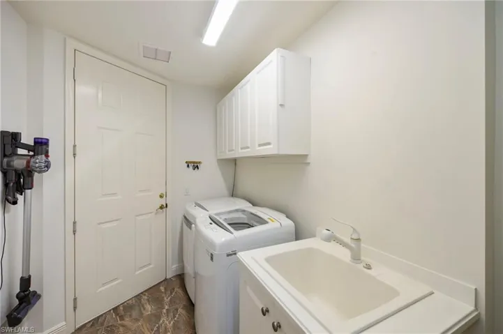Laundry room with separate washer and dryer and cabinet space and tiled floor