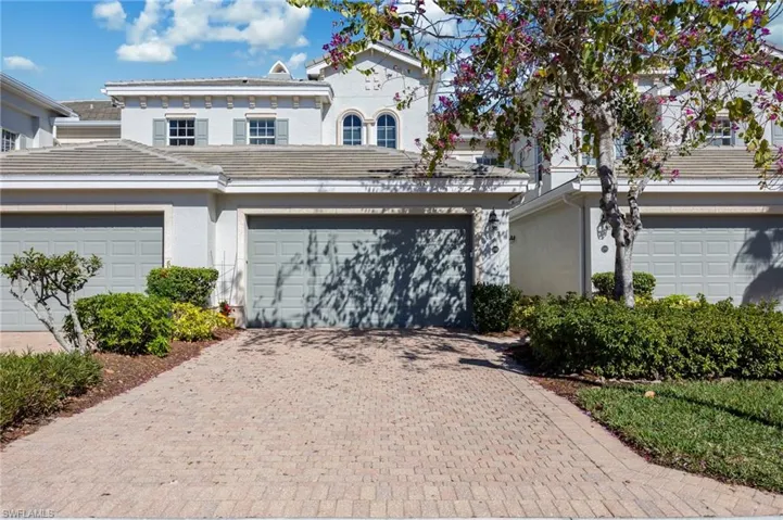 Mediterranean / spanish-style house with stucco siding, decorative driveway, and a garage