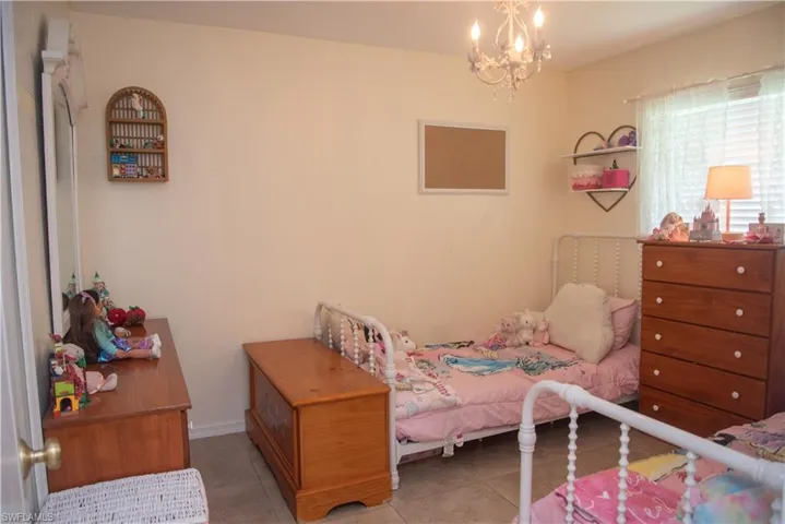 Tiled bedroom featuring a chandelier