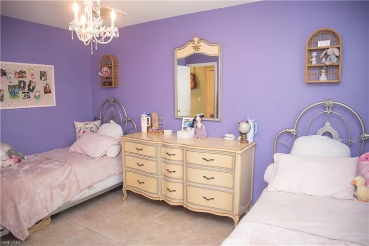 Tiled bedroom featuring a notable chandelier